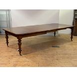 A large mid-19th century mahogany dining table, the rectangular top with rounded corners pulling out