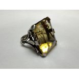 A striking single stone citrine dress ring, the large emerald-cut stone claw set on scroll and
