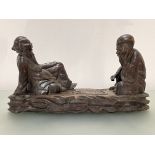 A Chinese wooden carving of two seated figures playing "Go", unsigned. Height 23cm, length 43cm