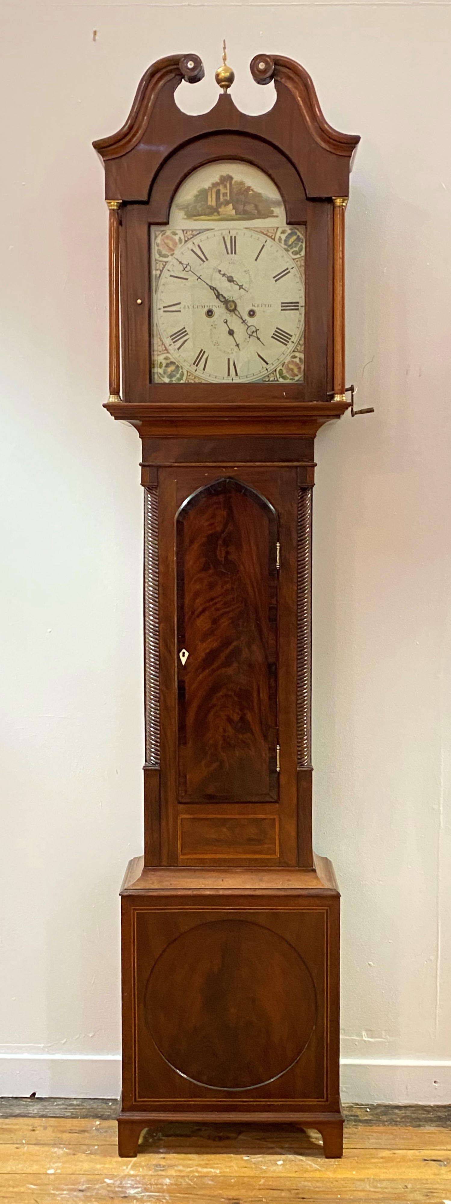 An early 19th century mahogany longcase clock, the swan neck pediment over arched hood door