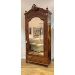 A French quarter sawn veneered rosewood armoire, early 20th century, the arched top with urn