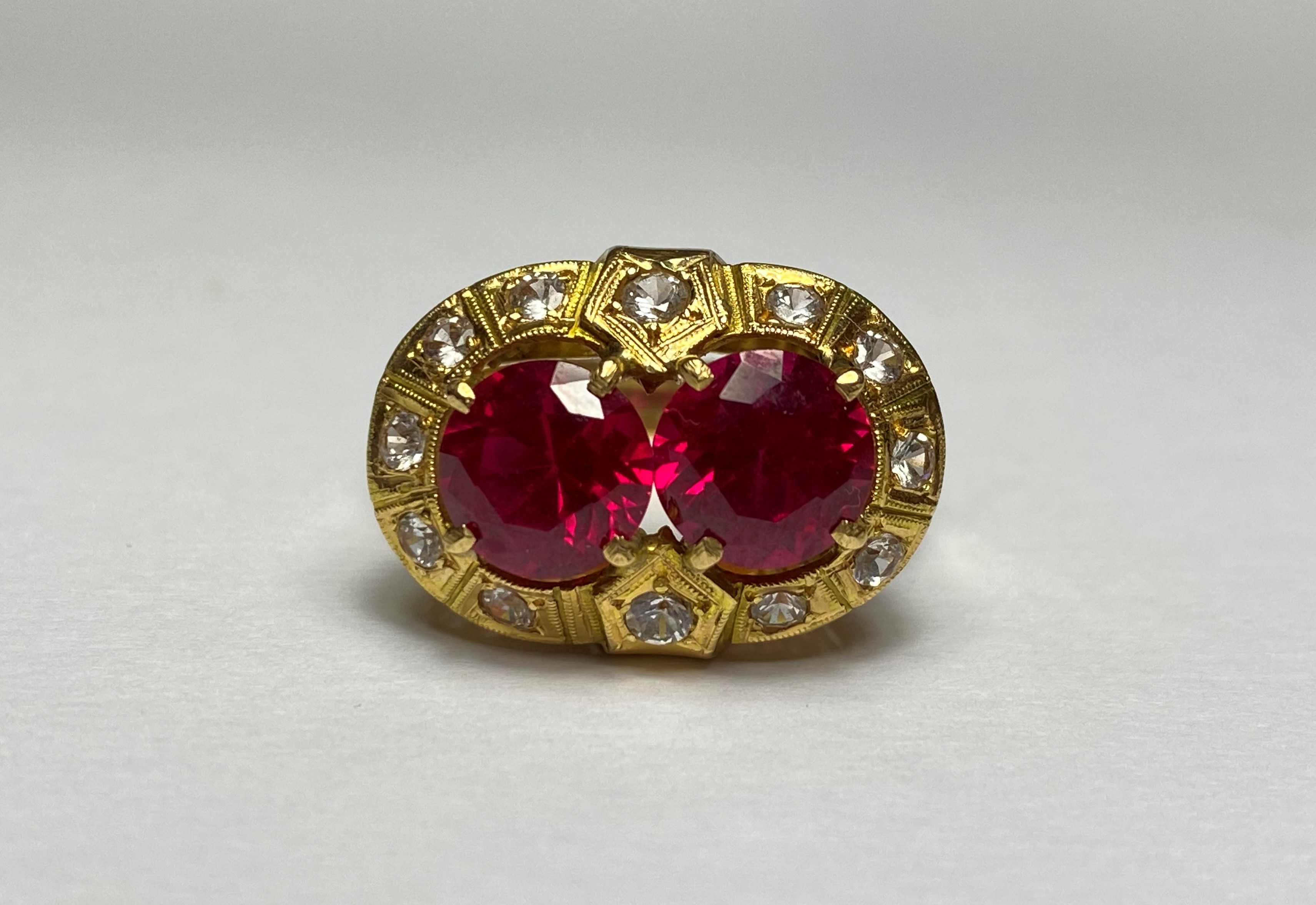 A striking synthetic ruby dress ring, the two round-cut rubies claw-set within a band of round