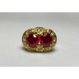 A striking synthetic ruby dress ring, the two round-cut rubies claw-set within a band of round