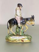 A 19th century Staffordshire figure of Sancho Panza, on a naturalistic base. Height 19.5cm