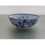 A late 18th century blue and white Delft bowl, possibly Bristol, painted with a floral spray and