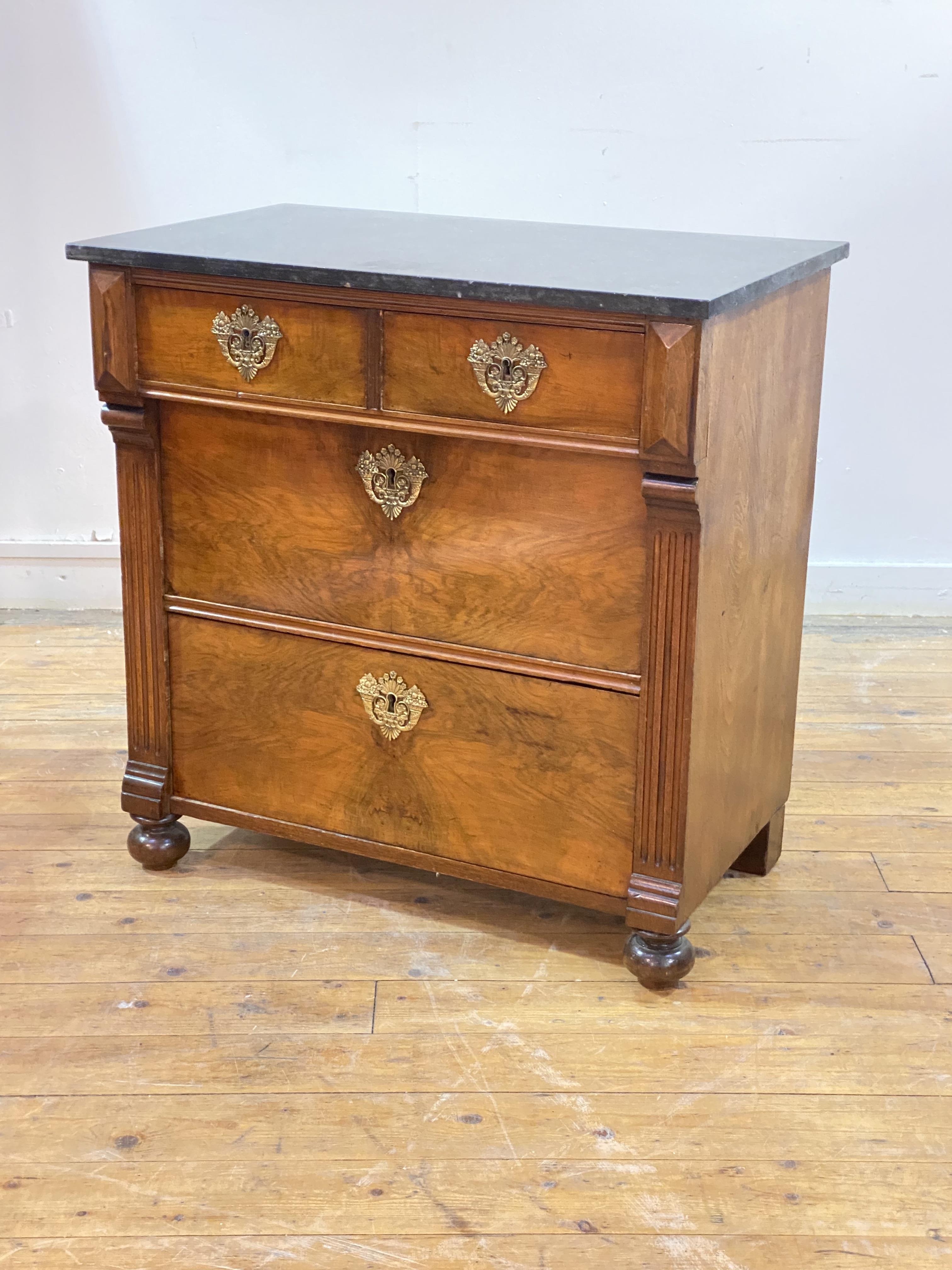 A late 19th century French walnut commode in the Empire taste, the black variegated marble top