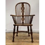 An early 19th century yew and elm Windsor arm chair, the double hoop, spindle and pierced splat back