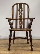 An early 19th century yew and elm Windsor arm chair, the double hoop, spindle and pierced splat back