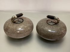 A pair of granite curling stones, early 20th century, each with ebonised handle over a white metal