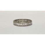 A diamond full hoop eternity ring, of channel-set baguette diamonds, in unmarked white metal. Ring