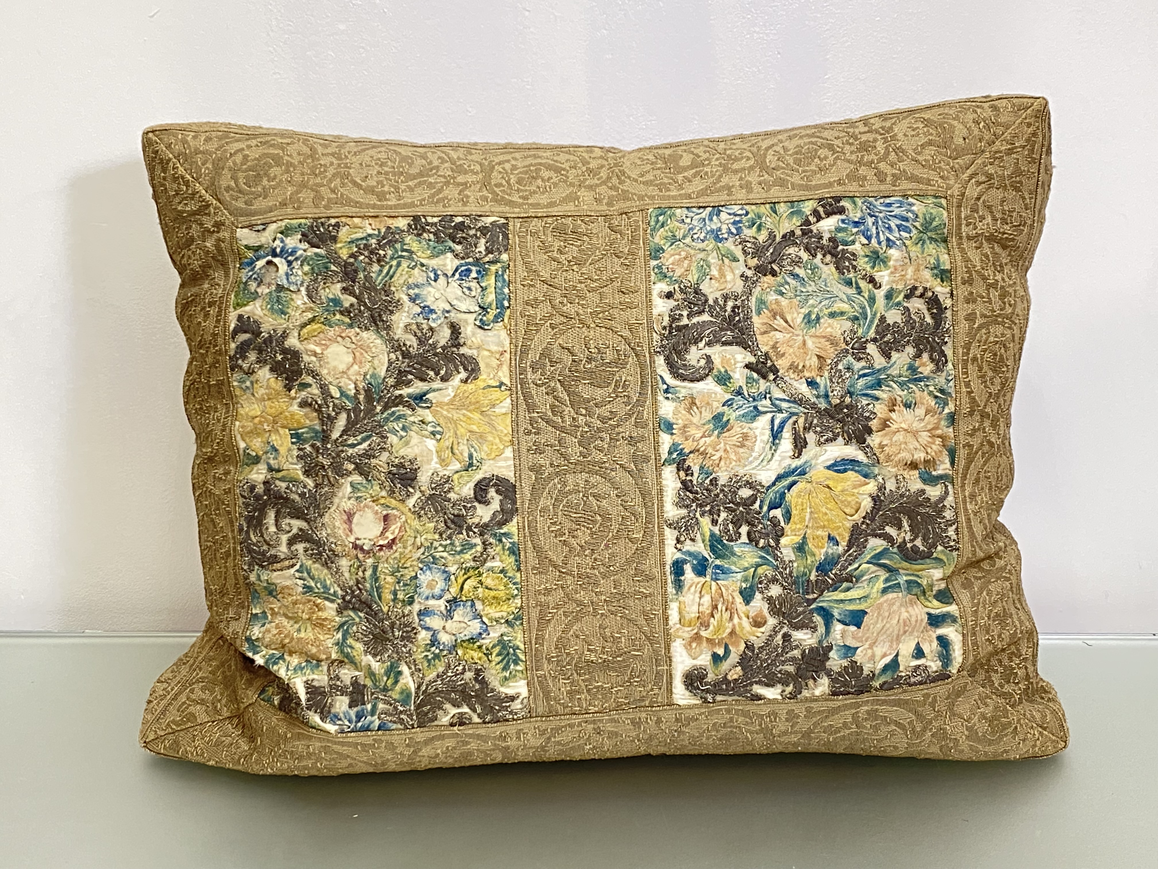 A large cushion incorporating a pair of textile panels, possibly 18th century, each worked in