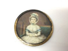 Georgian portrait miniature on ivory of a young woman, shown seated with her arms crossed, in gilt f