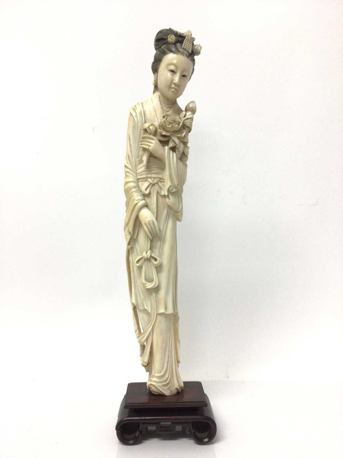 Large 19th century Japanese ivory tusk figure of a woman, shown wearing a long robe and holding flow