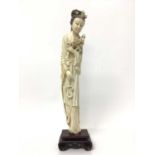 Large 19th century Japanese ivory tusk figure of a woman, shown wearing a long robe and holding flow