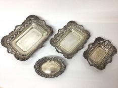 Three silver graduated rectangular dishes with pierced and floral decoration and one other oval silv
