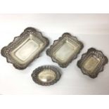 Three silver graduated rectangular dishes with pierced and floral decoration and one other oval silv