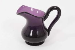 A 19th century amethyst tinted glass helmet shaped cream jug