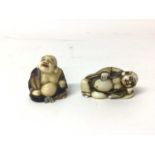 Two 19th century Japanese carved figures of Buddha, one a netsuke and shown reclining, the other pai