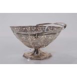 Edwardian silver sugar basket of navette form with pierced and engraved decoration, swing handle and