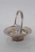 Edwardian silver bonbon dish of circular form with pierced decoration and central swing handle, rais