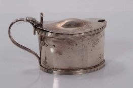 George V silver mustard pot of oval form with receded borders and blue glass liner, (Birmingham 1917