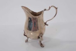 George V silver milk jug of baluster form, raised on three hoof feet, (London 1929), maker Goldsmith