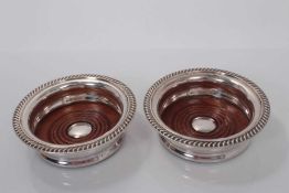 Pair of Contemporary silver plated wine coasters by Barker Ellis, with gadrooned borders and wooden