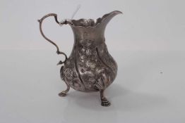 George III silver milk / cream jug of baluster form, with later chased decoration, raised on three h