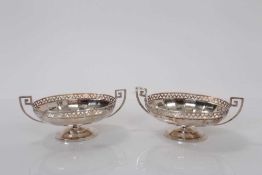 Pair George V silver bon bon dishes of oval from with pierced border and Greek key handles raised on