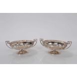 Pair George V silver bon bon dishes of oval from with pierced border and Greek key handles raised on