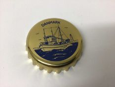 Georg Jensen novelty bottle opener in the form of an oversized bottle cap, decorated with a boat