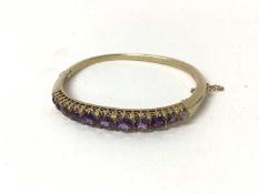 Victorian style gold and amethyst hinged bangle with graduated round mixed cut amethysts and diamond