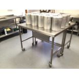 A stainless steel freestanding preparation bench, with drawer, on castors, 1200 mm