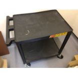 A black plastic two tier tea trolley, on castors, 610 mm x 460 mm