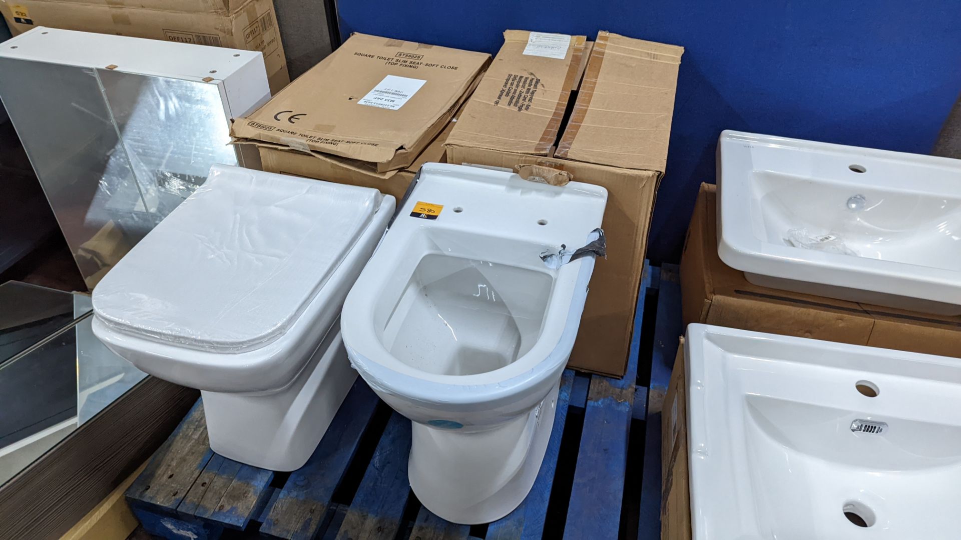 Pair of assorted toilet pans, one of which includes a seat