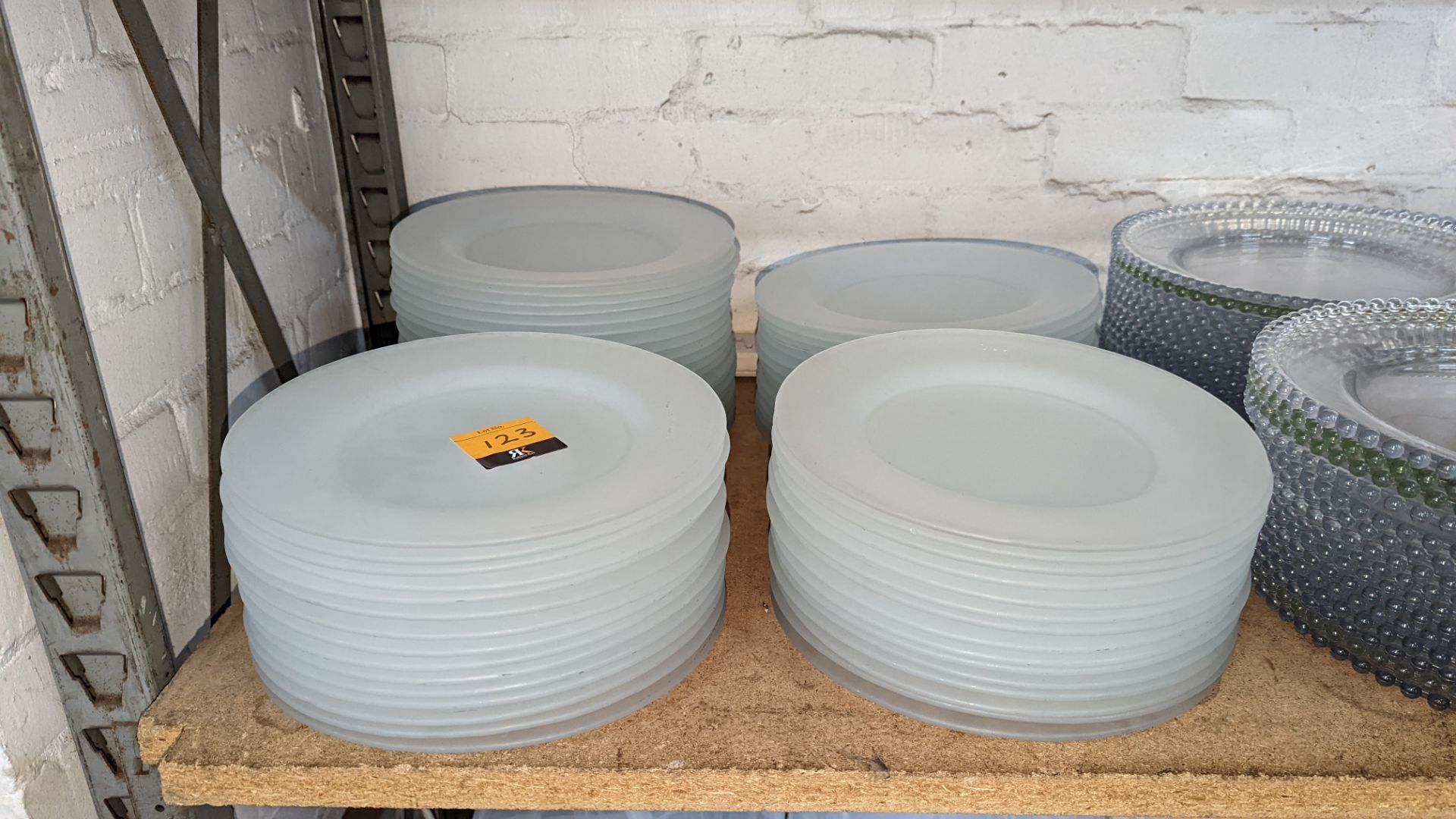 65 off opaque colourless glass plates each measuring approximately 27cm diameter