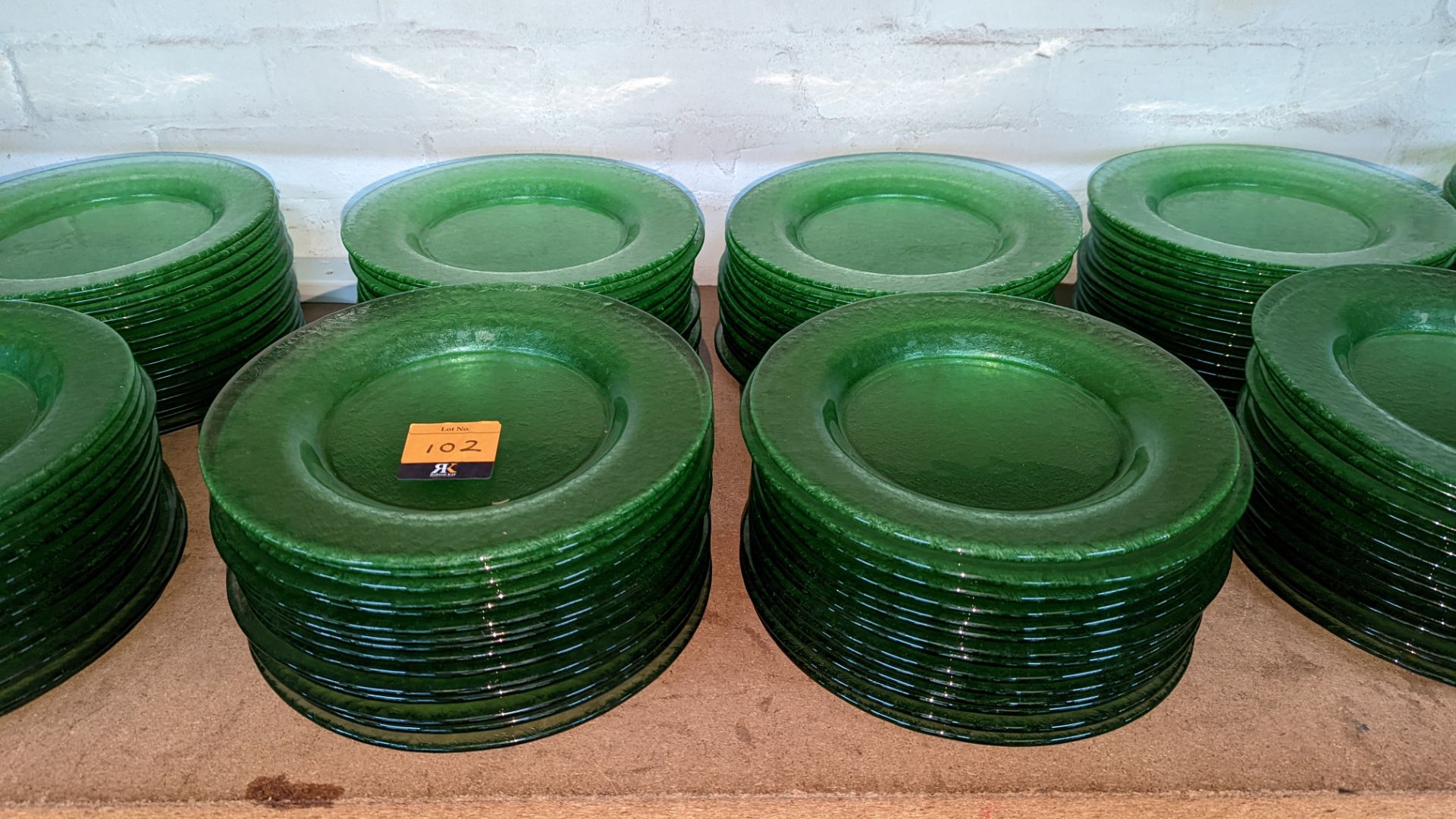 60 off green glass plates each measuring approximately 27cm diameter