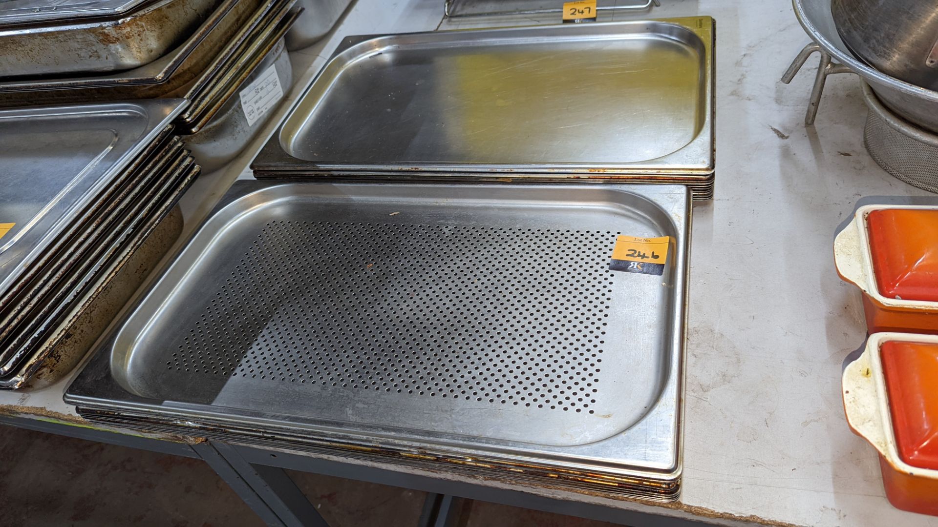 2 stacks of stainless steel rectangular trays including one perforated tray