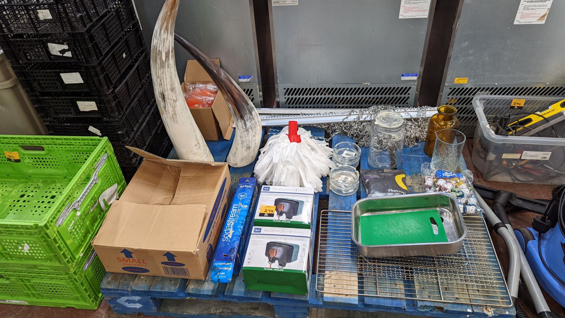 The contents of a pallet of assorted items including paper bags, weatherproof sockets, ornamental it
