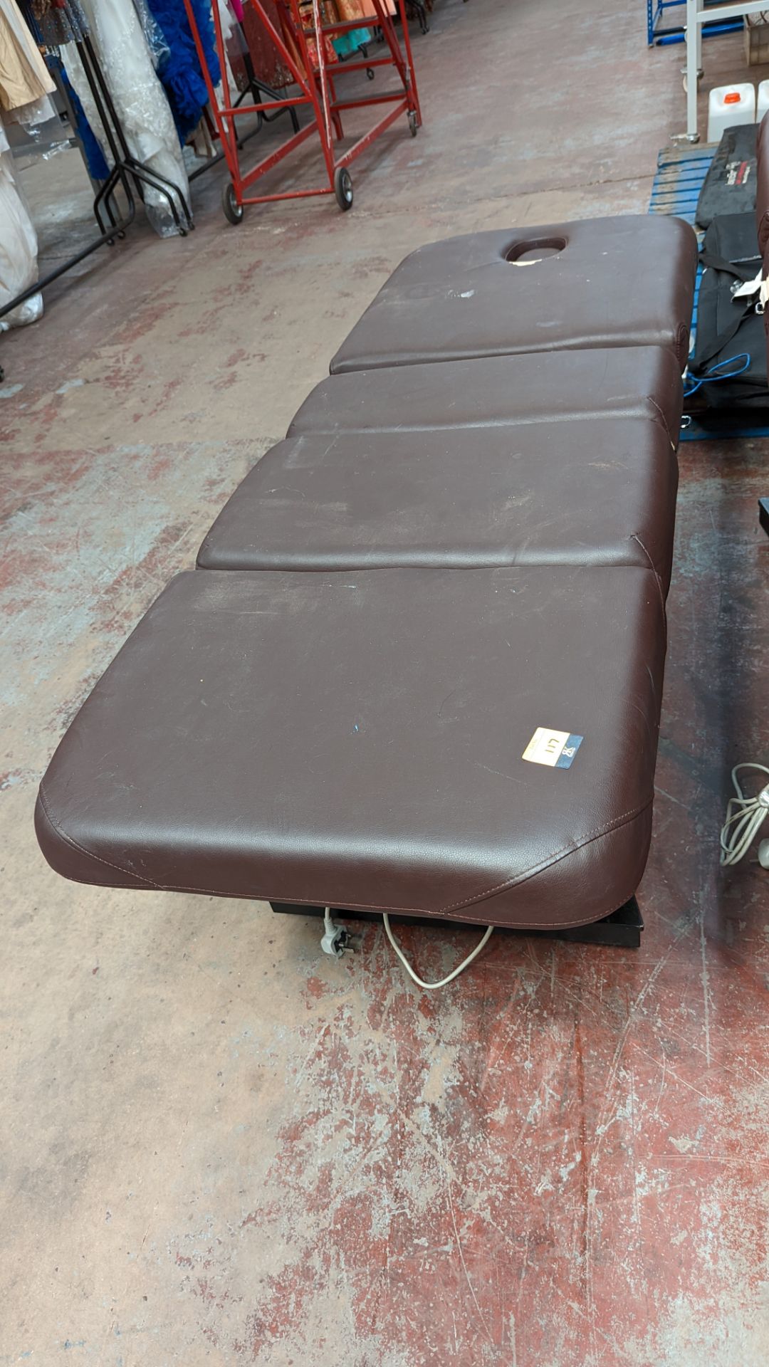 Beauty treatment bed in brown leather/leatherette on black wooden base with electric controller