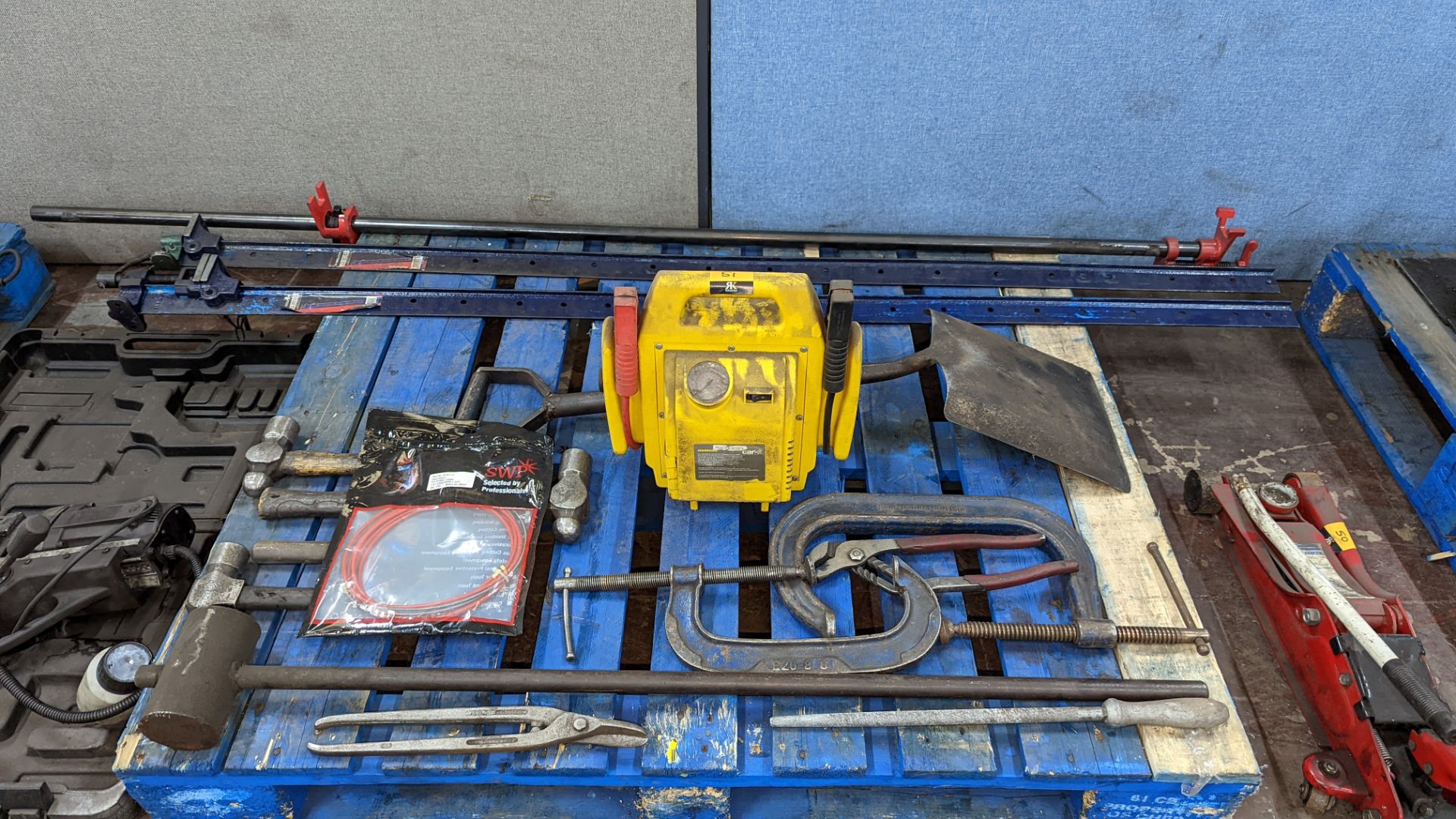 Contents of a pallet of miscellaneous items comprising clamps, hammers, battery starter & more