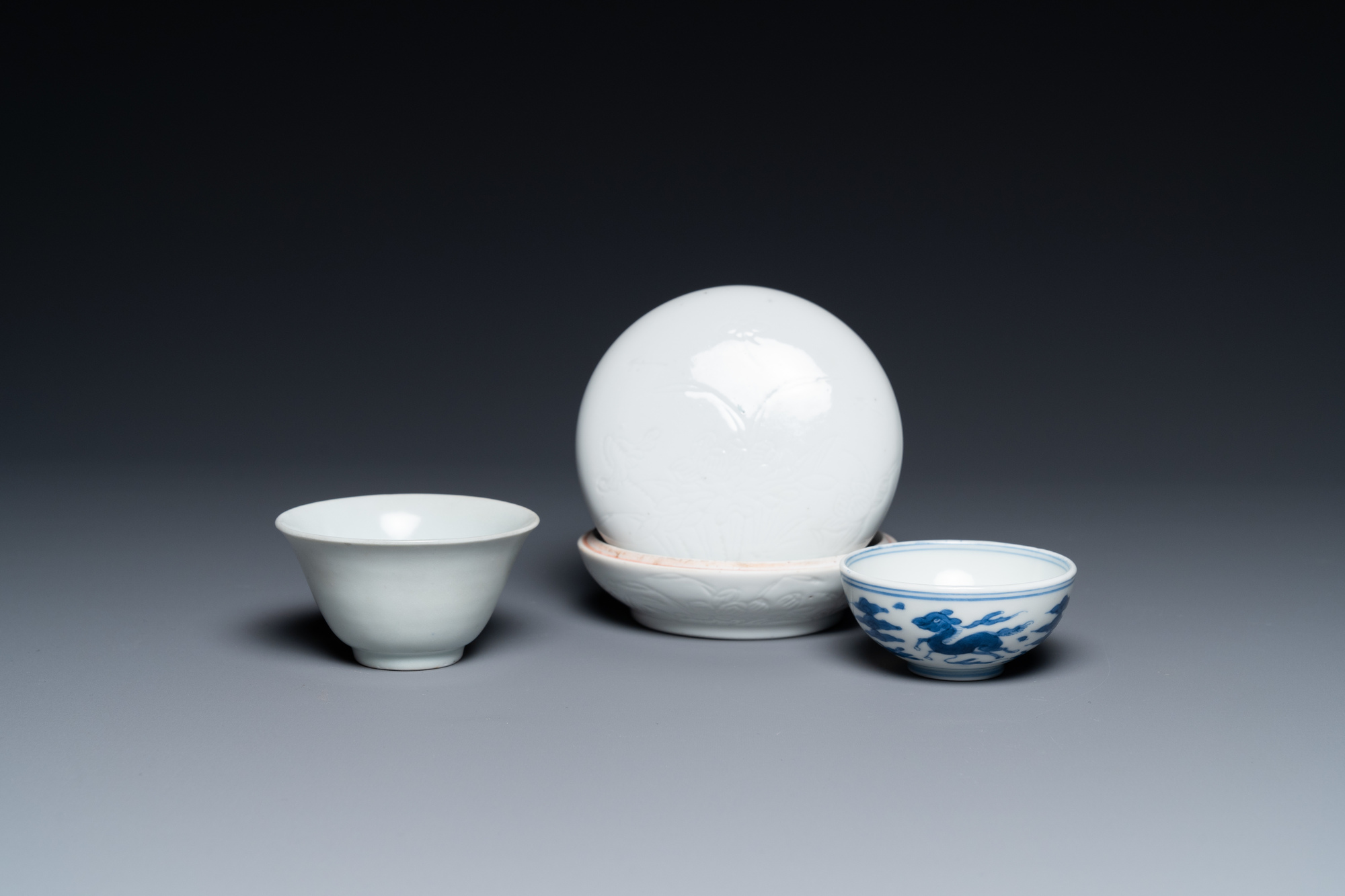 A Chinese white-glazed bowl, a small blue and white bowl and a covered box with incised design, Ming