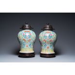 A pair of Chinese famille rose vases with wooden covers and stands, 19th C.