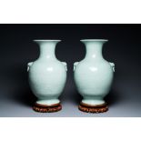 A pair of Chinese monochrome celadon vases with underglaze design on wooden stands, Qianlong mark, 1