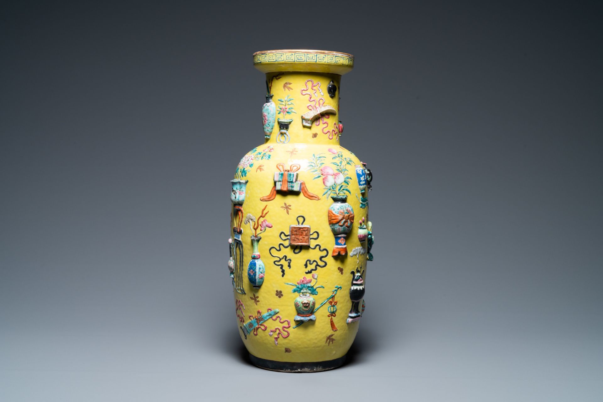 A Chinese yellow-ground famille rose rouleau vase with applied 'antiquities' design, 19th C.