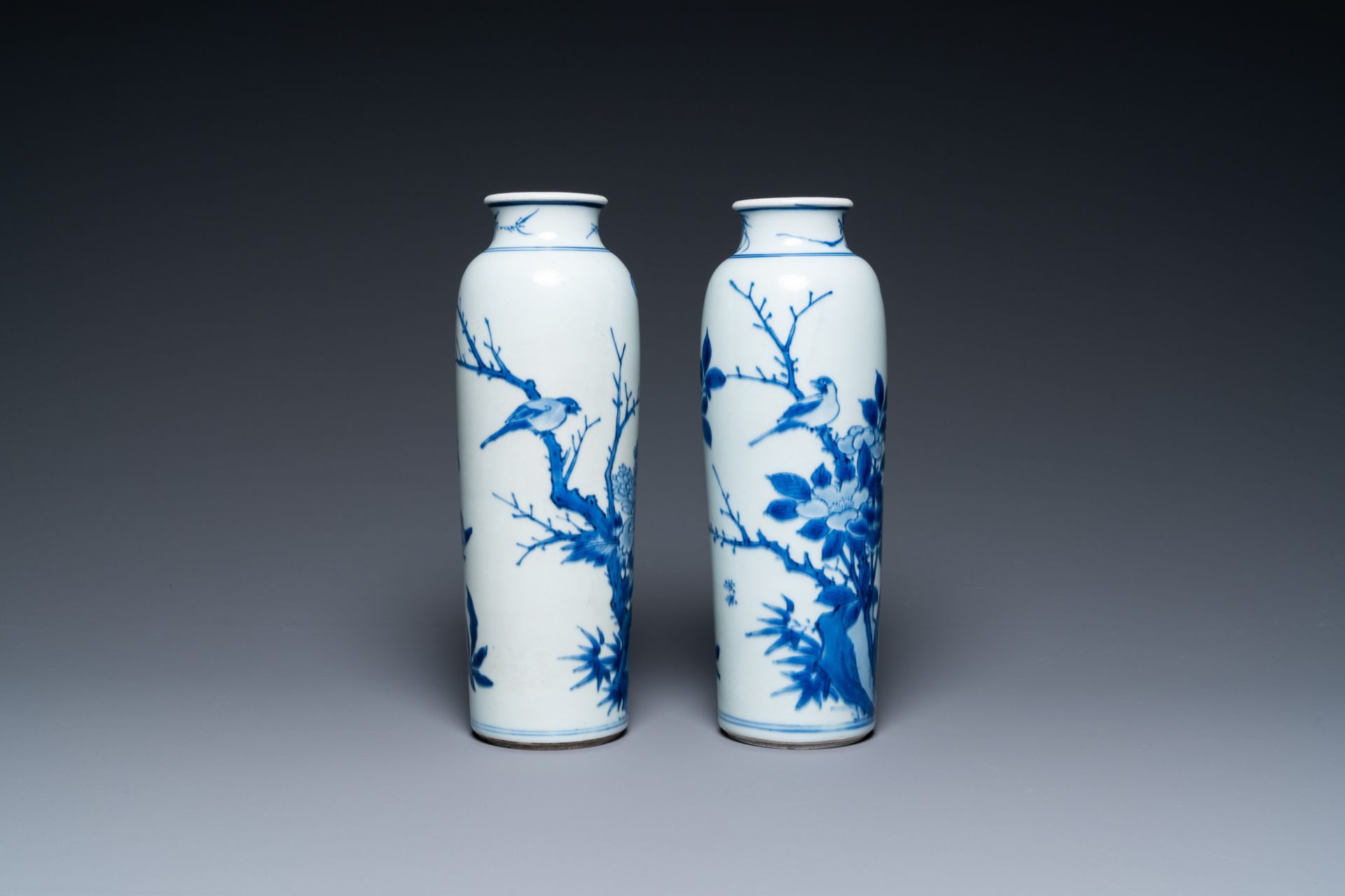 A pair of Chinese blue and white rouleau vases with birds among blossoming branches, Transitional pe