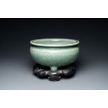 A Chinese celadon-glazed tripod censer with peony scrolls, 18/19th C.