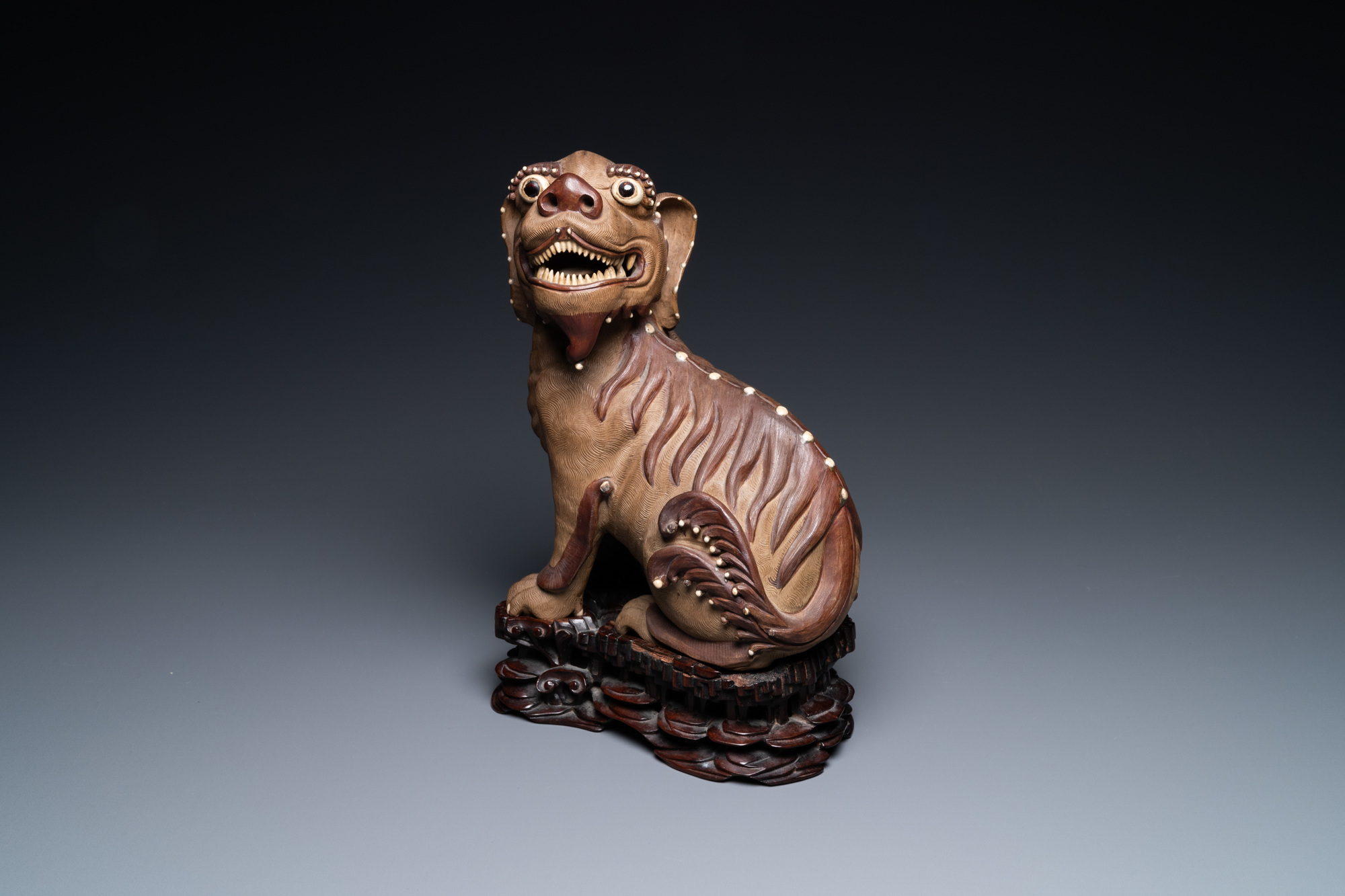 A Chinese Yixing stoneware dog on wooden stand, 19th C