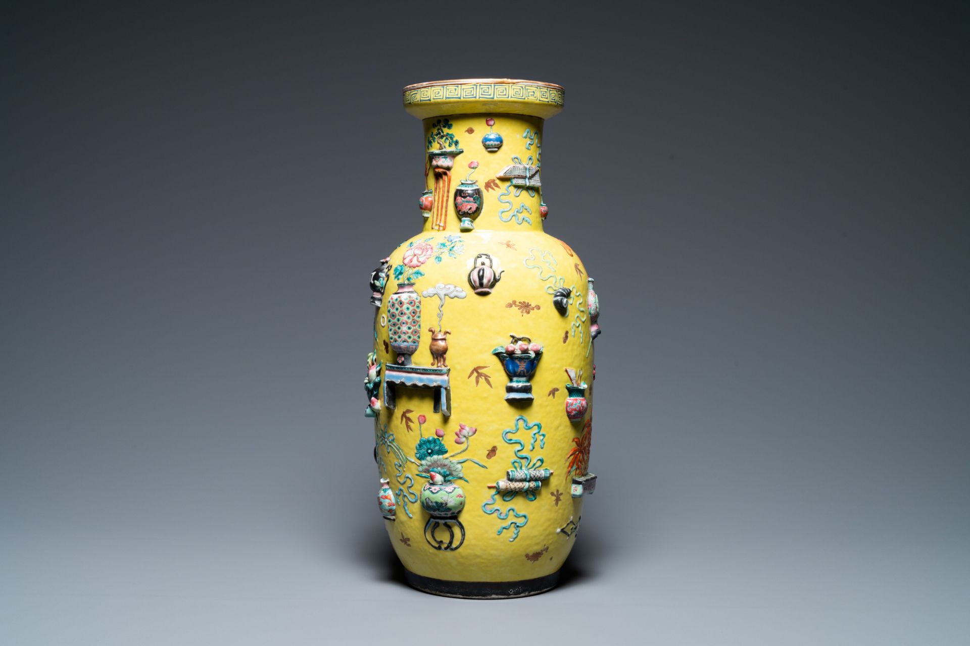 A Chinese yellow-ground famille rose rouleau vase with applied 'antiquities' design, 19th C. - Image 3 of 7