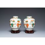 A pair of Chinese famille verte vases on wooden stands, 'hare' mark, 19th C.